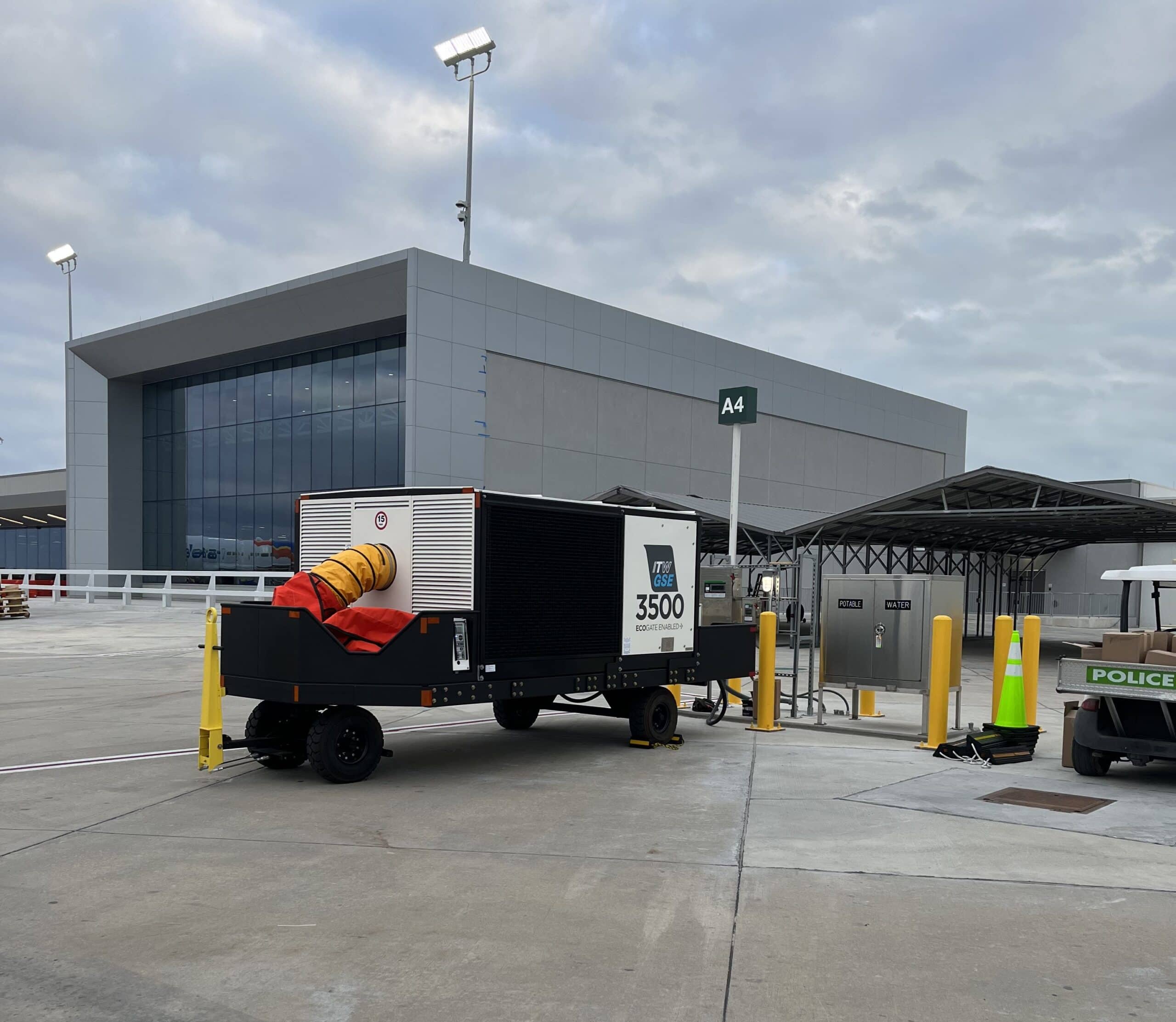 Trailer-mounted ITW GSE 3500 Mobile PCA parked near a terminal building at an airport, ready for aircraft cooling